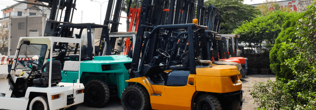 various forklifts sitting in a yard